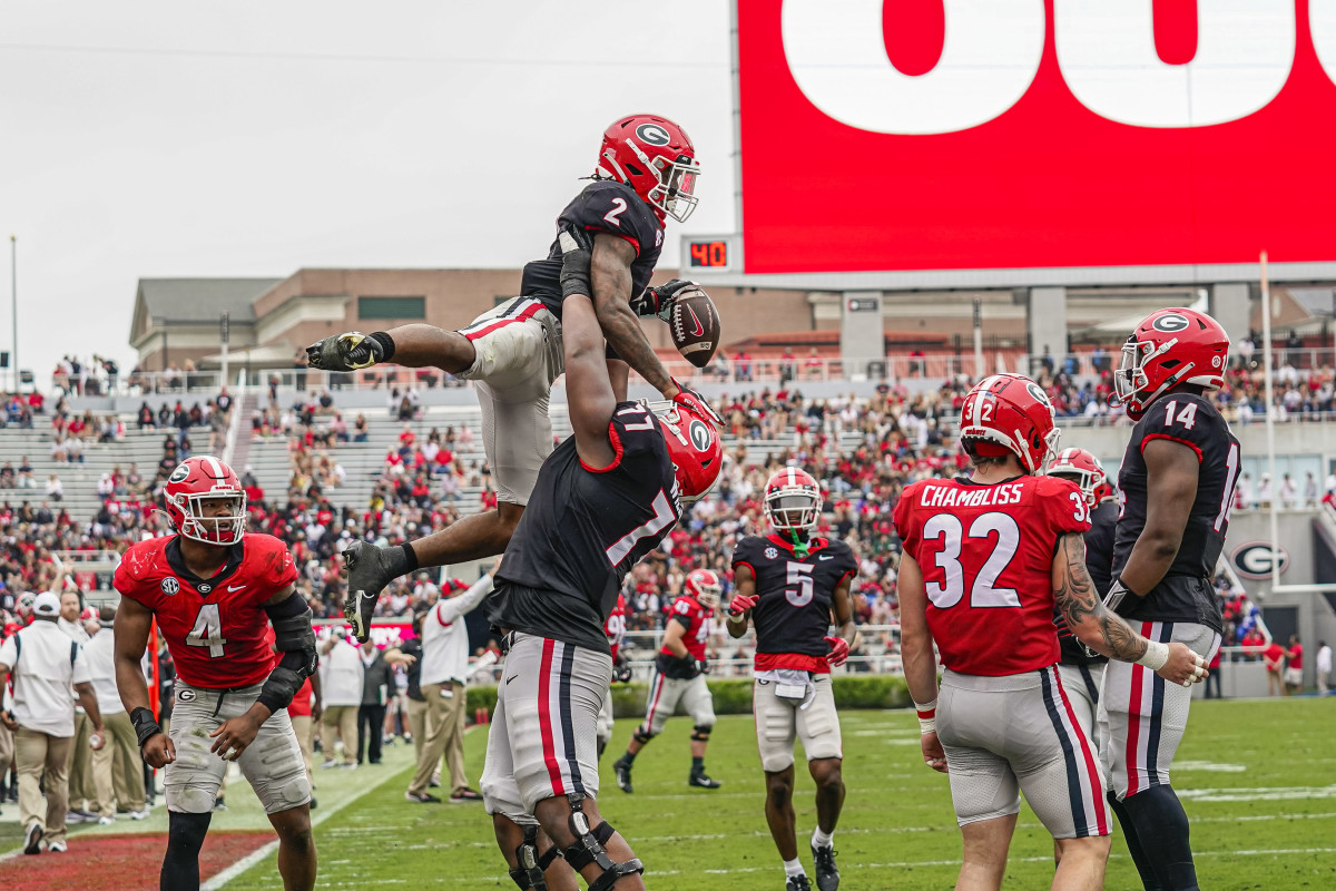 Georgia Bulldogs running back Kendall Milton gets lifter by offensive lineman Devin Willock in the air after scoring in Georgia’s spring game